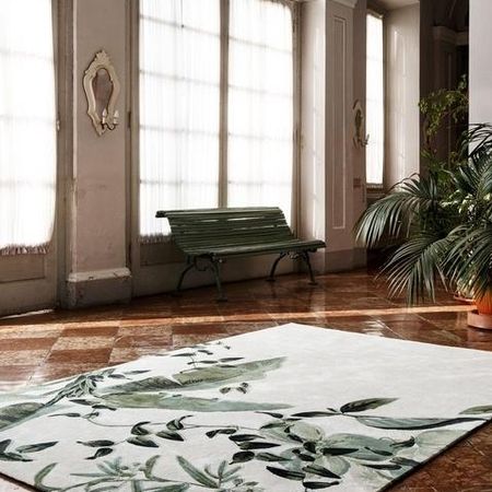 Ein stilvoller, botanischer Teppich mit grünen Blattmustern auf poliertem Marmorboden