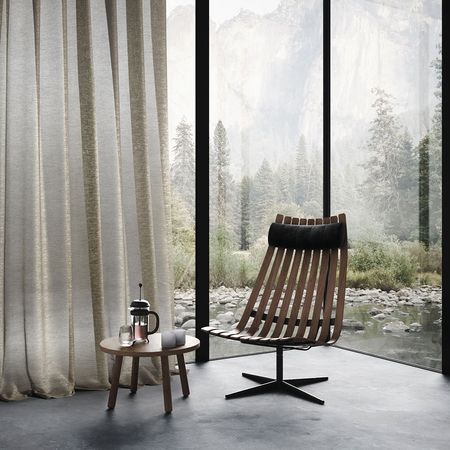 Moderne Sitzecke mit Holzstuhl und rundem Tisch, umgeben von transparenten Vorhängen