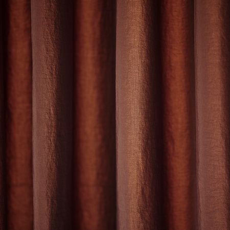 Nahaufnahme von reichen, strukturierten braunen Vorhängen, die elegant drapiert sind