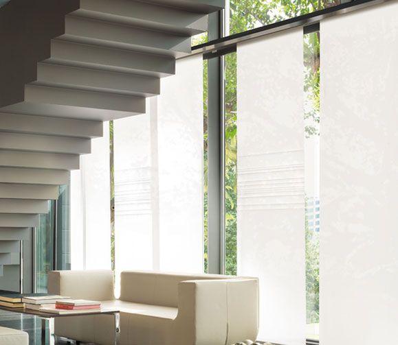 Modernes Interieur mit einem eleganten weißen Sofa und einer Glaswand mit durchsichtigen Vorhängen