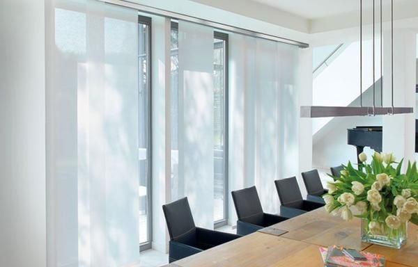 Moderner Besprechungsraum mit durchsichtigen Vorhängen, schwarzen Stühlen und einem Holztisch