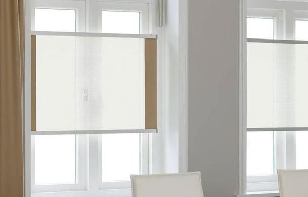 Zwei moderne Fenster mit hellbeigen Rollläden in einem minimalistischen Raum mit weißen Wänden