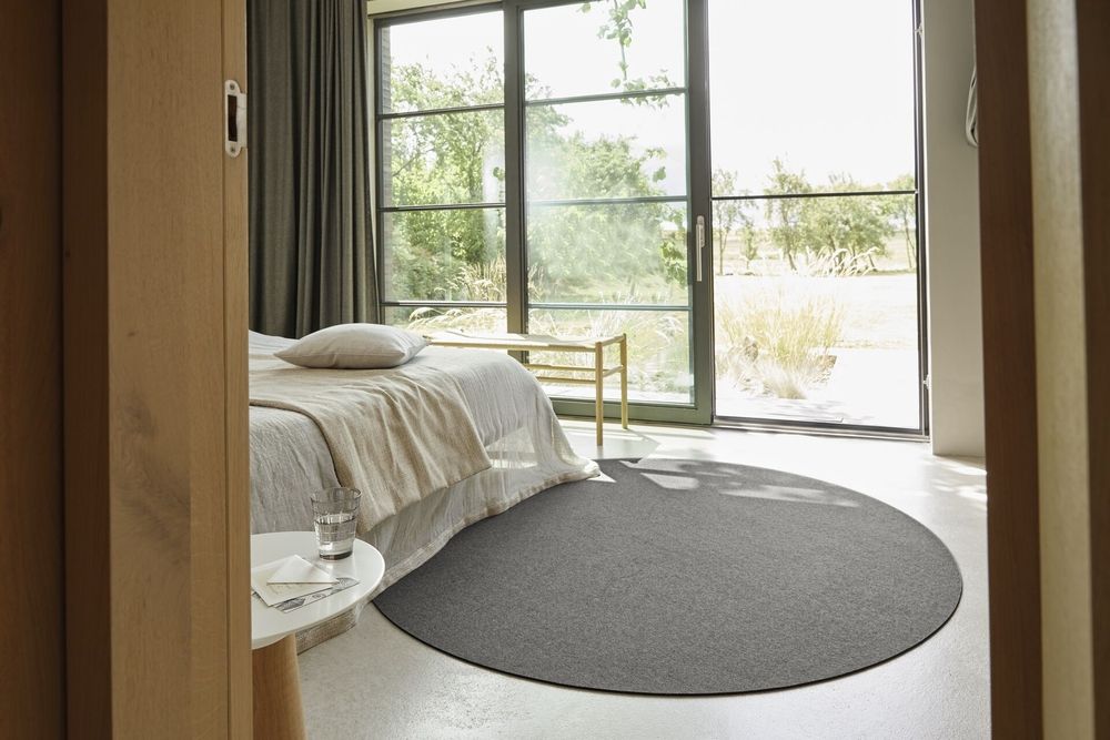 Gemütliches Schlafzimmer mit Bett, Fenster und einem stilvollen Teppich zur Dekoration.